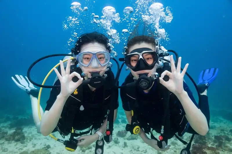A professional divers buddy assisting guest with Asia Rainforest Resort in the Semporna archipelago near Semporna
